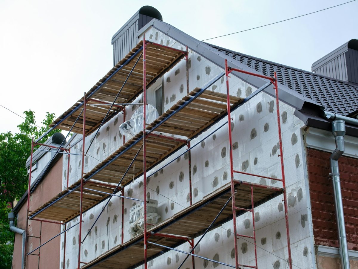 Building facade under renovation works with construction scaffolding frame.