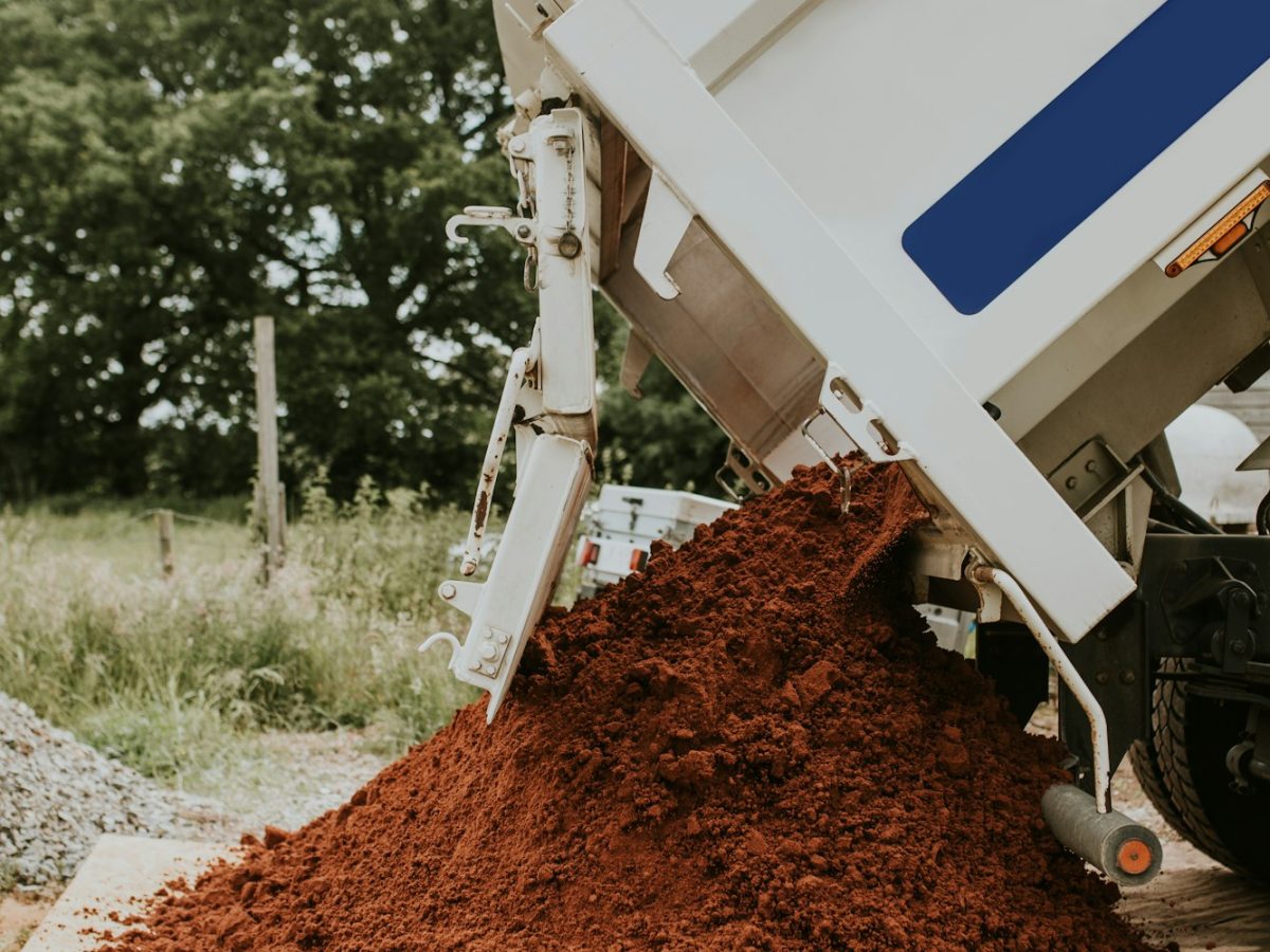 Sand truck unloading soil on a construction site